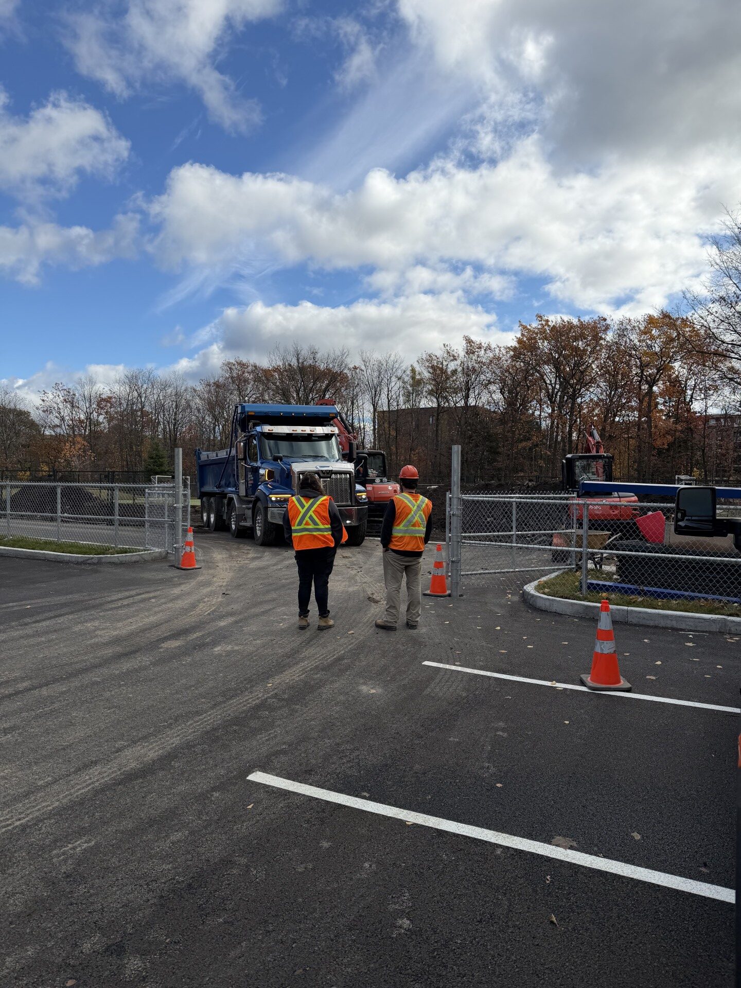Camion et travailleurs devant une clôture