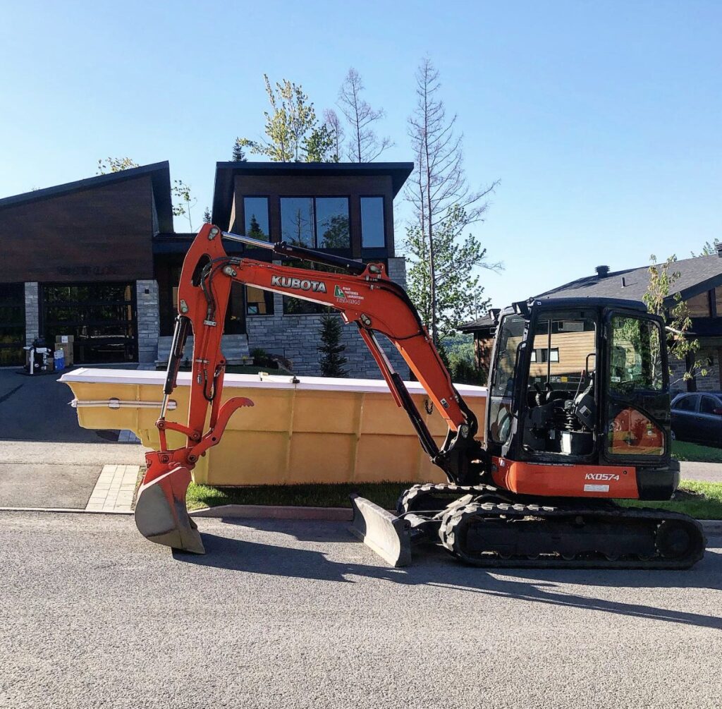 Excavatrice près d'une maison moderne.